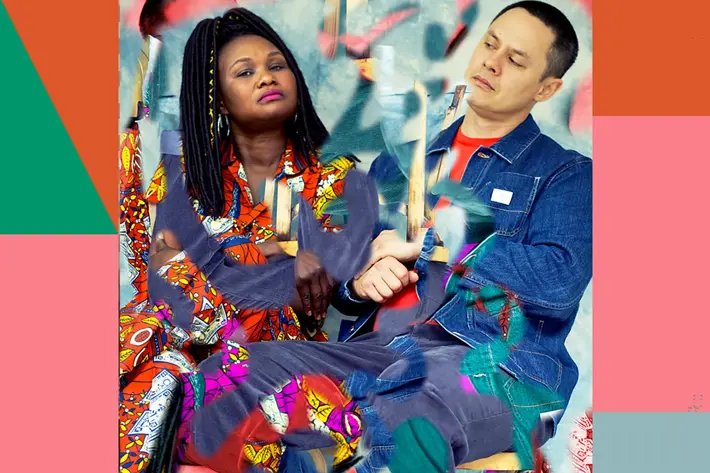 Emma D and ADP from Wrong Way Up sitting down and looking curiously at each other.