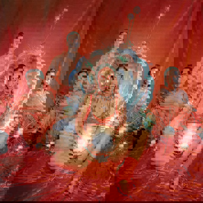 Miguel, Nic, Maddy and Alex surround a magical silver clam against a silky red backdrop. Miguel, Nic and Alex wear light red overalls and red gloves. Maddy wears a silver chainmail two piece created by 'Catholic Guilt' with 'Chou Chou the Label' under garments and holds a silver sphere with white pearls attached. 
