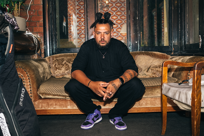 A photo of Kiwat Kennell sitting on a vintage couch